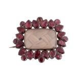 A mid 19th Century garnet and hairwork brooch, circa 1860, with a central rectangular cushion