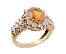 A citrine and diamond ring, the central oval shaped citrine in a four claw setting, within a