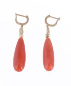 A pair of coral and diamond ear pendents, the polished coral drops suspended from oval brilliant