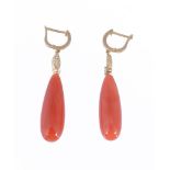 A pair of coral and diamond ear pendents, the polished coral drops suspended from oval brilliant