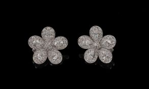 A pair of diamond flower head ear clips, set throughout with brilliant cut and pear shaped