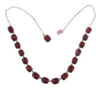 A Georgian garnet necklace, circa 1820, composed of oval shaped flat cut foil backed garnets in