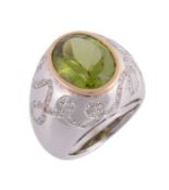 A peridot and diamond bombe ring, the collet set oval shaped peridot, on a wide band set with
