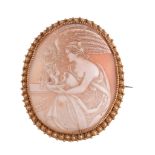 A late 19th Century shell cameo brooch, the oval shell cameo carved with the image of Hebe and the