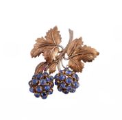 A sapphire foliate brooch, the two clusters of circular shaped sapphires on a textured stem with