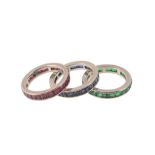 Three gem set eternity rings, each set with either baguette cut rubies, sapphires or emeralds,