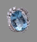 A diamond and aquamarine dress ring, the oval mixed cut aquamarine within an abstract surround of