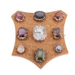 A late Victorian 18 carat gold multi gem set shield brooch, the shield shaped panel with foliate