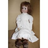 A Kammer & Reinhardt bisque head girl doll, with brown sleeping eyes, open mouth, pierced ears (