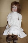 A Kammer & Reinhardt bisque head girl doll, with brown sleeping eyes, open mouth, pierced ears (