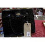 A black crocodile skin handbag by Asprey London, with label to inside