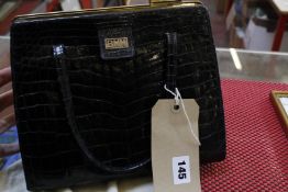 A black crocodile skin handbag by Asprey London, with label to inside