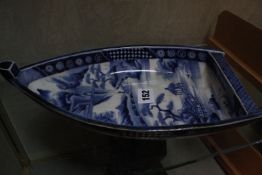 A Japanese blue and white boat shaped dish, decorated with landscape, 30cm long