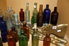 A set of 19th Century brass fire tools and a collection of old beer and pharmacy bottles