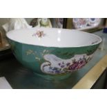 A Continental china bowl, green ground with floral decoration and gilt highlights, 29cm in