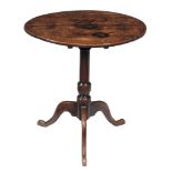 An oak tripod table , early 18th century, the oval tilt top above turned...  An oak tripod