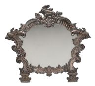 A South American silver on copper easel framed dressing table mirror, of cartouche shape and