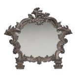 A South American silver on copper easel framed dressing table mirror, of cartouche shape and