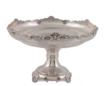 A silver circular comport, maker's mark rubbed, London 1921, with a shell and scroll shaped rim,