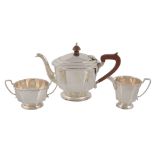 An Art Deco silver three piece tea service, the tea pot and cream, jug by Adie Bros, the sugar