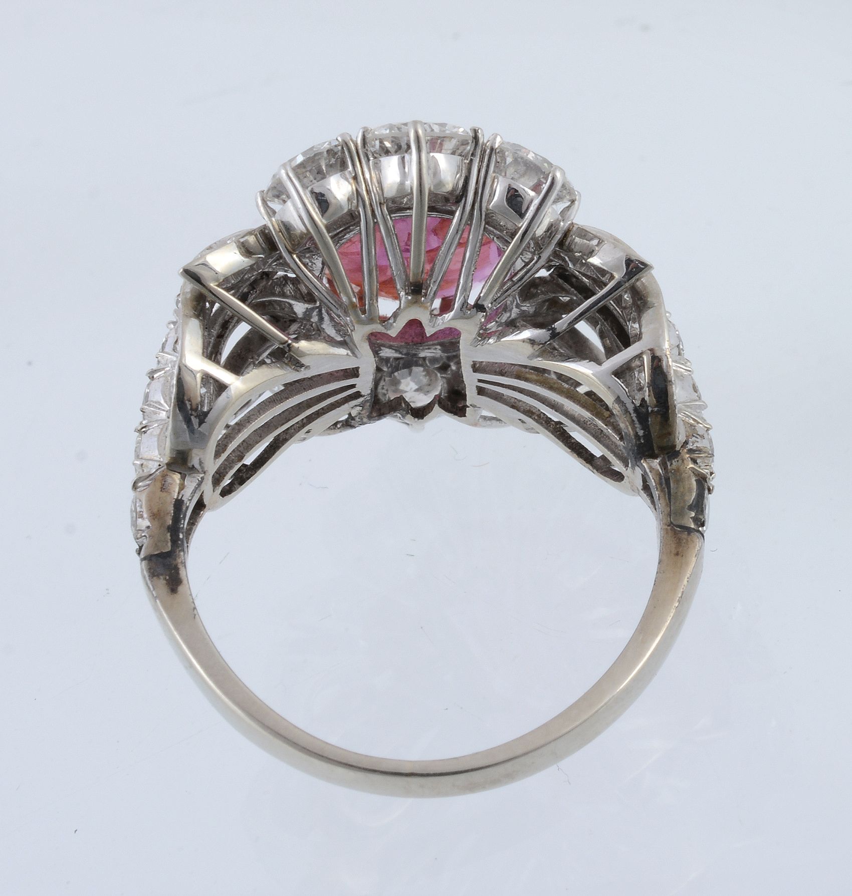 A ruby and diamond cluster dress ring, the central oval mixed cut ruby within a pierced brilliant - Image 2 of 3