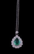An emerald and diamond pendant, the central pear shaped emerald collet set within a surround of