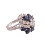 A sapphire and diamond ring, the pear shaped sapphires claw set within an abstract surround of
