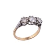A three stone diamond ring, the brilliant cut diamonds in claw settings, the shank stamped PLAT,