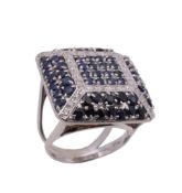 A sapphire and diamond ring, the square shaped panel set with circular shaped sapphires and