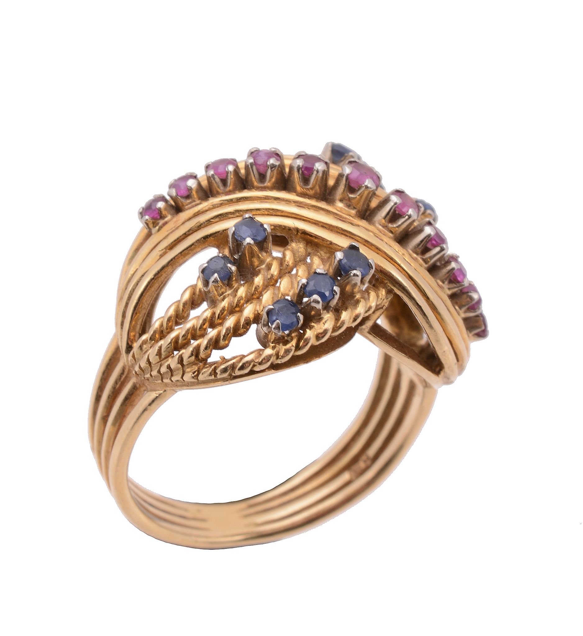 A ruby and sapphire cross over dress ring, of twisting design set with circular shaped rubies and