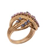 A ruby and sapphire cross over dress ring, of twisting design set with circular shaped rubies and