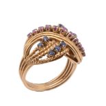 A ruby and sapphire cross over dress ring, of twisting design set with circular shaped rubies and