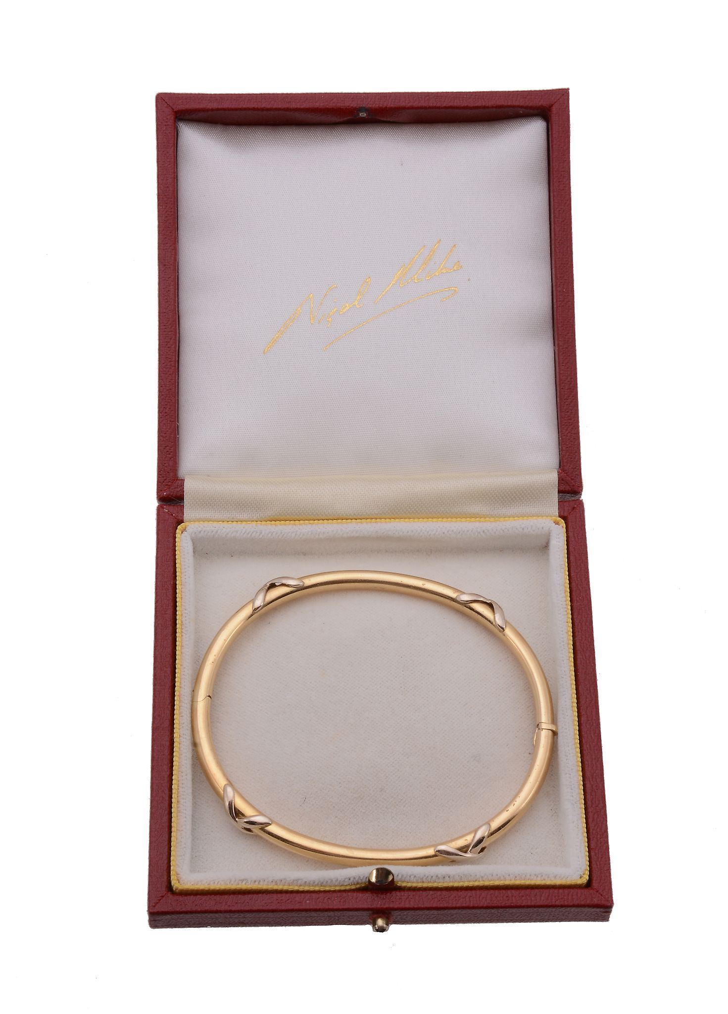 An 18 carat gold hinged bangle, the polished bangle with applied cross motifs, with a London