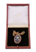 A Victorian enamel and half pearl bird pendant, the polychrome enamel bird upon an oval rose cut