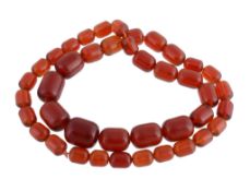 A red amber bead necklace, composed of graduated oval shaped polished red amber beads, 66cm long