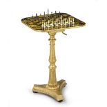 A Regency Tilt-Top Games Table England circa 1830, the board is enriched with armorial motifs