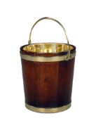 A Mahogany Peat Bucket England circa 1800, with broad brass bands and with hinged brass handle on