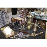 A large brass Persian style ewer, two smaller similar pots, two carved wooden easel stands, three