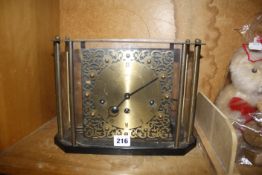 A 20th Century glazed mantel clock with brass face, the movement marked Franz Hermle, 30cm wide