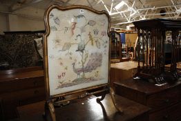 A yew wood quartetto nest of tables and a walnut fire screen with inset needlework panel depicting