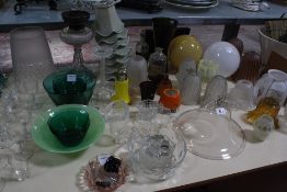 A glass oil lamp, a selection of glass lamp shades, together with a green glass fruit set, bowls,