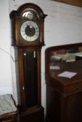 A Georgian style oak longcase clock brass face, bearing a small presentation plaque dated 1934