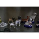 A selection of porcelain and pottery model dogs, to include a Meissen pug, a Beswick pug, a pair