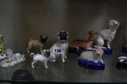 A selection of porcelain and pottery model dogs, to include a Meissen pug, a Beswick pug, a pair
