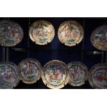 A set of nine Chinese famille rose plates, decorated with figures, within borders of flowers,
