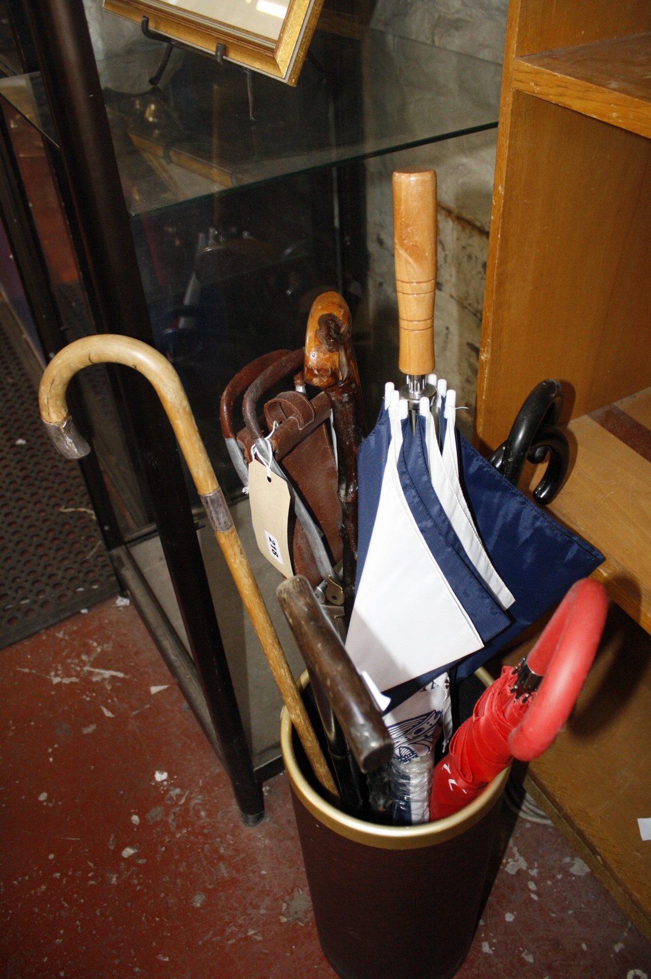 A stick stand with assorted walking sticks and umbrellas, to include a silver mounted walking