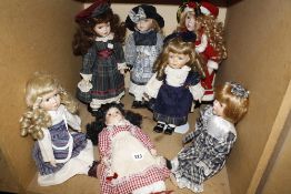 Eight Country Collection dolls and some stands.
