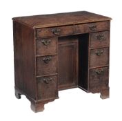 A George III oak kneehole desk, circa 1820, the rectangular top, with moulded edge, two frieze