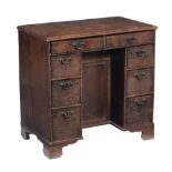 A George III oak kneehole desk, circa 1820, the rectangular top, with moulded edge, two frieze