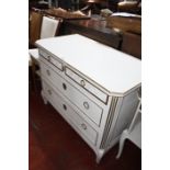 A white painted chest of drawers together with a marble top bedside table.